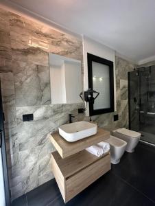 a bathroom with a sink and a toilet and a mirror at Vista Templi Luxury Suite in Agrigento +56 photos
