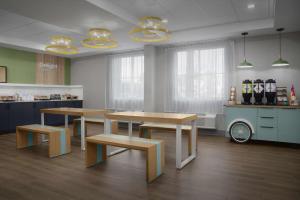 a kitchen with two tables and benches in a room at Spark by Hilton Miami Doral in Miami