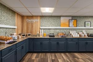 una cocina con armarios azules y una barra con pan en Spark by Hilton Sarasota Siesta Key Gateway, en Sarasota