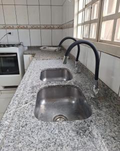 a kitchen counter with a sink and a microwave at SOBRADO - 5 quartos - 4 banheiros - 4 vagas de garagem in Campo Grande