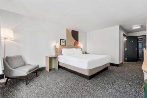 a hotel room with a bed and a chair at Spark By Hilton St. Augustine I 95 in Saint Augustine