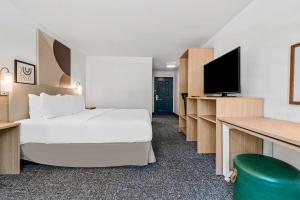 a hotel room with a bed and a flat screen tv at Spark By Hilton St. Augustine I 95 in Saint Augustine