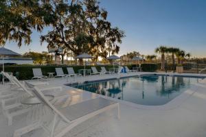 basen z białymi leżakami i stołami w obiekcie Spark by Hilton Savannah Midtown w mieście Savannah