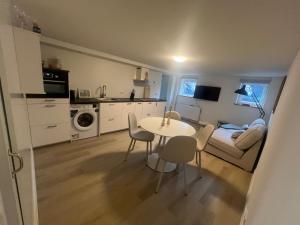 a kitchen and living room with a table and chairs at The Souterrain in Nijmegen