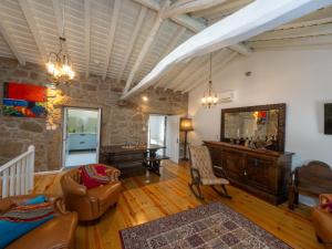 ein Wohnzimmer mit Möbeln und einer Steinmauer in der Unterkunft Caminho Gerês - Heritage Eco-Cottage - jacuzzi in Lindoso