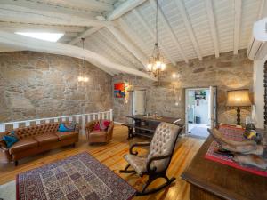 ein Wohnzimmer mit Sofa und Tisch in der Unterkunft Caminho Gerês - Heritage Eco-Cottage - jacuzzi in Lindoso