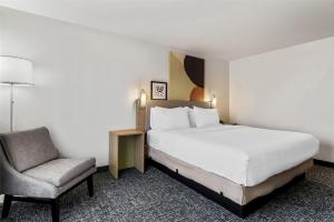 une chambre d'hôtel avec un lit et une chaise dans l'établissement Spark By Hilton Merrillville, à Merrillville 22 autres photos
