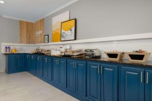 a kitchen with blue cabinets and a counter top at Spark By Hilton Evansville East, In in Evansville