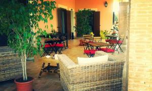 a patio with tables and chairs and a table with a tree at Villa Elegance in Ladispoli