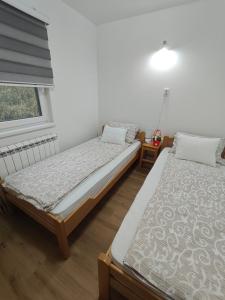 Dos camas individuales en una habitación con ventana. en Jovičića Kuća, en Mokra Gora