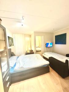a bedroom with two beds and a tv on the wall at Exclusive Central-Home in Central Oslo- for five people in Oslo