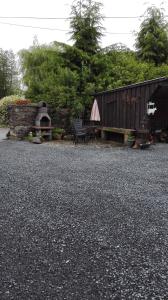 un patio con banco y horno de pizza en Aux doux rêves, en Provèdroux