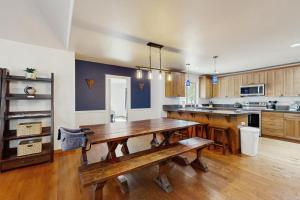 a large kitchen with a wooden table and benches at Wood Wonderland in Sunriver