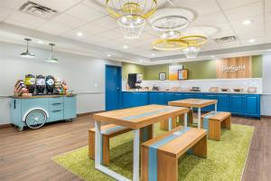 シェファーズビルにあるSpark by Hilton Shepherdsville Louisville Southの青いキャビネットとテーブル、キッチンを備えたカフェテリア