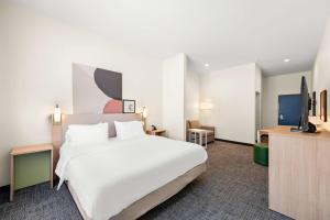 MansfieldにあるSpark By Hilton Mansfieldの大型ベッド1台、テレビが備わる客室です。