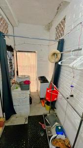 a room with a wall with buckets and a broom at Recámara en Casa Alan in Puerto Vallarta