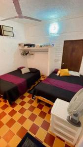 a room with two beds in a room at Recámara en Casa Alan in Puerto Vallarta