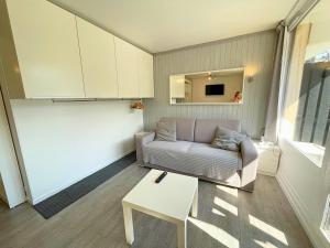 een woonkamer met een bank en een tafel bij Studio cabine rénové avec cuisine équipée aux Menuires - FR-1-452-2 in Les Menuires +12 foto's