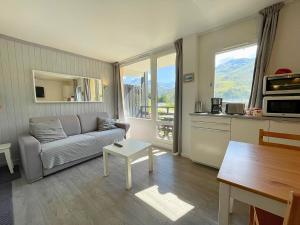 een woonkamer met een bank en een tafel bij Studio cabine rénové avec cuisine équipée aux Menuires - FR-1-452-2 in Les Menuires