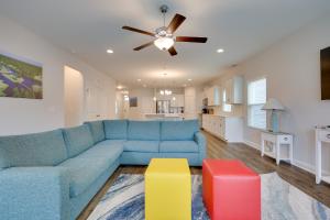 a living room with a blue couch and a ceiling fan at 3 Mi to Golf and Waterway Ocean Isle Beach Retreat! in Ocean Isle Beach