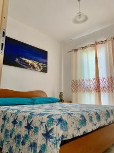 a bedroom with a bed with blue and white sheets at A 100 m dalla spiaggia in Torre Mozza