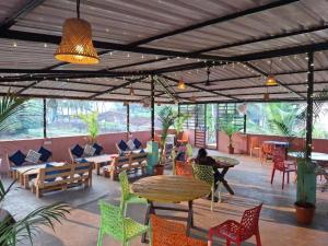 a restaurant with tables and chairs and people sitting at tables at Iris Homestay Goa in Anjuna