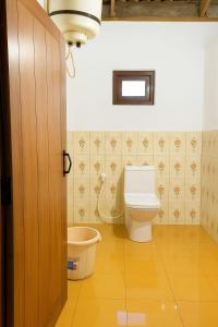 a bathroom with a toilet and a window at Tribal land homestay in Kushālnagar