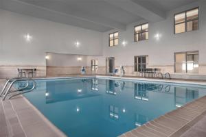 a swimming pool with blue water in a building at Spark By Hilton Albuquerque North I-25 in Albuquerque