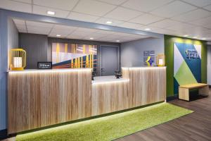 an office lobby with a reception desk and a bench at Spark By Hilton Jackson Ridgeland in Jackson +19 photos