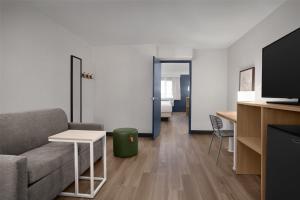a living room with a couch and a tv at Spark By Hilton Albuquerque North I-25 in Albuquerque