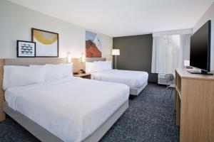a hotel room with two beds and a flat screen tv at Spark By Hilton Jackson Ridgeland in Jackson +18 photos