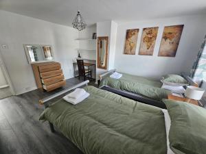 a bedroom with two beds and a dresser and a mirror at Stylish home in trendy area close to city centre, with parking in Belfast
