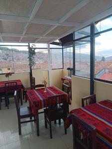 a restaurant with tables and chairs with a view at Marlon's INN Cusco II in San Antonio