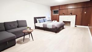 a bedroom with a bed and a couch and a fireplace at Private Room with Shared Washroom in Homestay in Vancouver