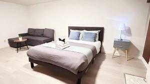 a bedroom with a large bed and a chair at Private Room with Shared Washroom in Homestay in Vancouver