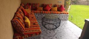 a couch with colorful pillows sitting on a patio at villa Folki in Oulad Zbir