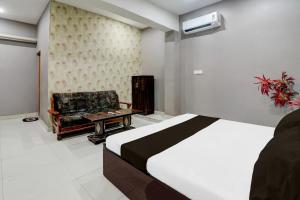 a hotel room with a bed and a chair at HOTEL O YASH RAJ PALACE in Rāe Bareli