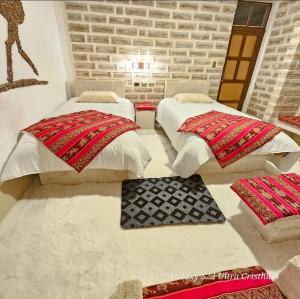 two beds in a room with red and white pillows at Hotel KAMANA in Chantani