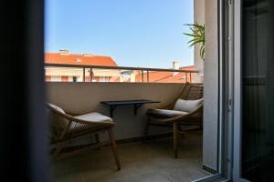 a balcony with two chairs and a table on it at Luxury rooms Iva in Zadar