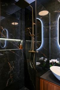 a black bathroom with a shower and a sink at Luxury Rooms by Iva in Zadar +36 photos