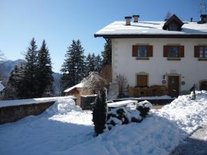 a house with a pile of snow in front of it at Achillea Bed & Breakfast in Vigo di Fassa