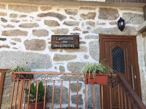 a sign on the side of a stone building with plants at Cantinho das Tecedeiras in Mondim de Basto