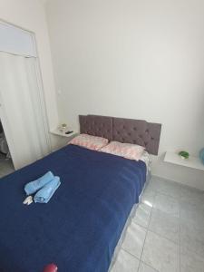 a bedroom with a blue bed with two towels on it at Praia de Botafogo próximo a Copacabana in Rio de Janeiro
