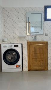 a washing machine and a mirror on a wall at Blue Villa in Mbour