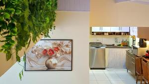 a kitchen with a vase of flowers in a kitchen at Vilars154 - Cavaleiros e Lagoa in Macaé