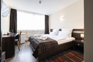 ein Hotelzimmer mit Bett, Schreibtisch und Fenster in der Unterkunft home Hotel in Wilhelmshaven + 47 Fotos