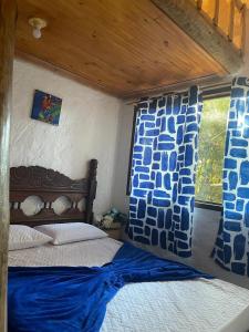 a bedroom with a bed with blue and white pillows at Pousada Lugar de Paz in Serra do Cipo