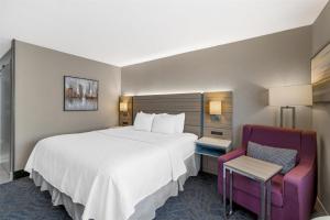 a hotel room with a large bed and a chair at Best Western Independence Kansas City in Independence +37 photos