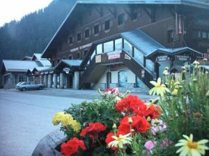 a building with a bunch of flowers in front of it at Chalet Club - Studio 2/3 personnes 17 m² MAE-2987 in Modane +3 photos