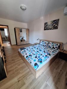 a bedroom with a bed with a blue comforter at Бобс апартменти in Kiten +2 photos
